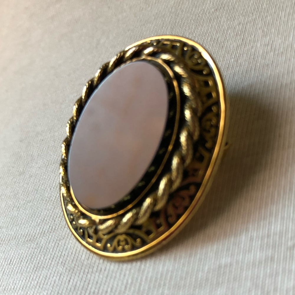 Brooch and pendant striking dark glass stone with exquisite gold tone setting.